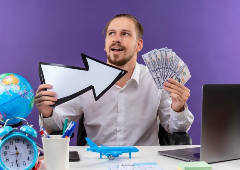 handsome-businessman-white-shirt-holding-white-arrow-showing-cash-looking-aside-with-smile-face-sitting-table-offise-purple-background_141793-53976